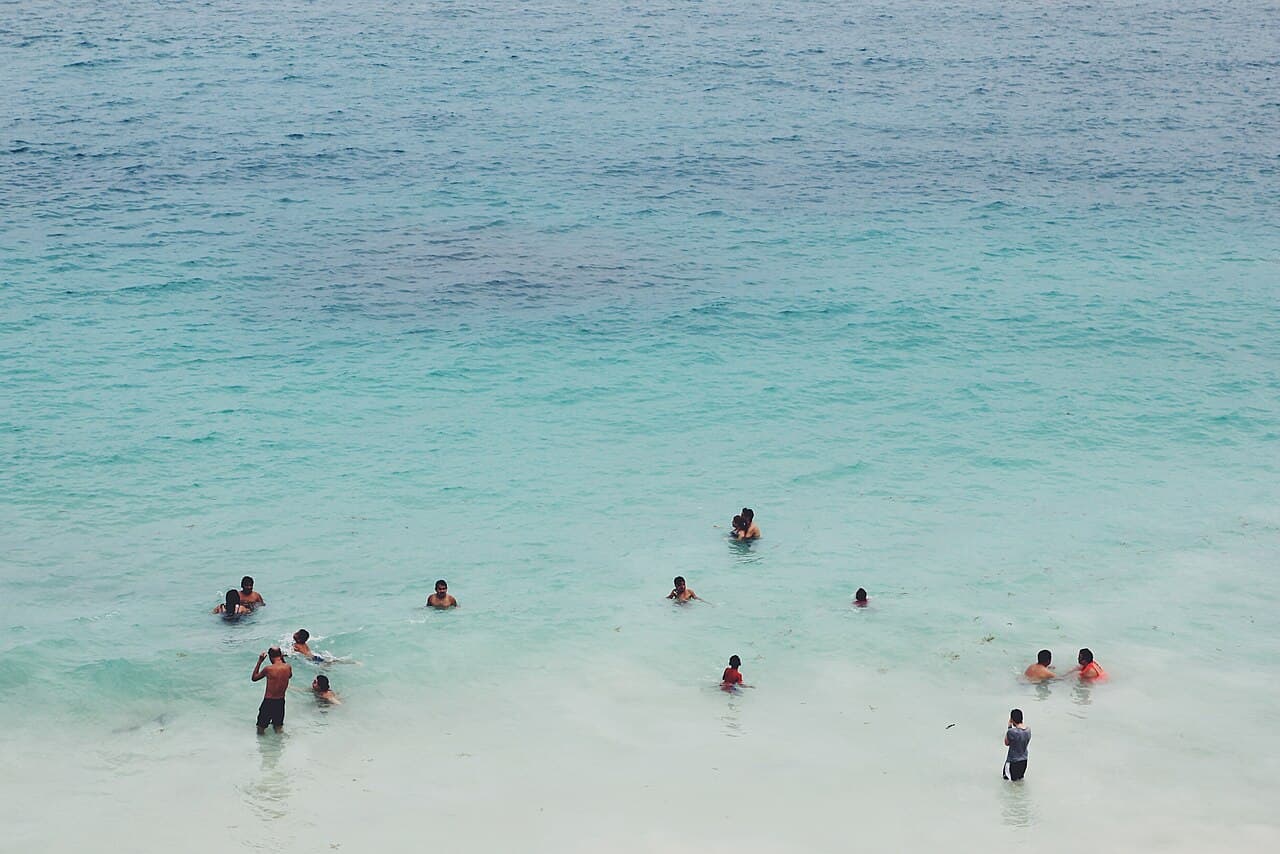 Gente nadando en agua turquesa del Caribe